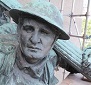 A bronze statue of a soldier. The statue is green with corrosion.
