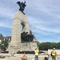 Six construction workers work on the concrete steps of the National War Memorial.